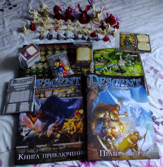 Descent board game box contents: rulebooks, campaign map, cards, dice, tokens, and miniatures laid out