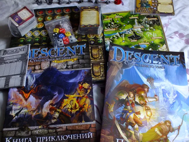 Descent rulebooks, campaign board, cards, dice, and token bags spread out on table