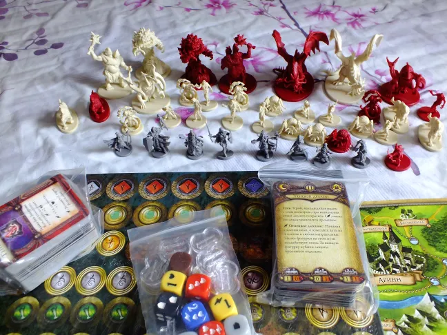 All miniatures lined up with cards, dice, and token bags in front