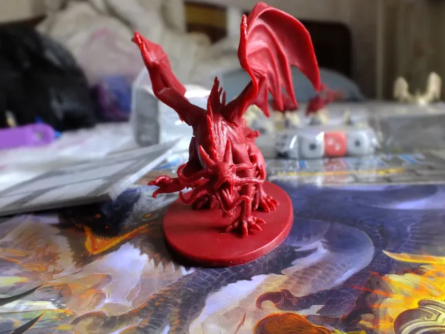 Red winged demon miniature close-up standing on the rulebook cover