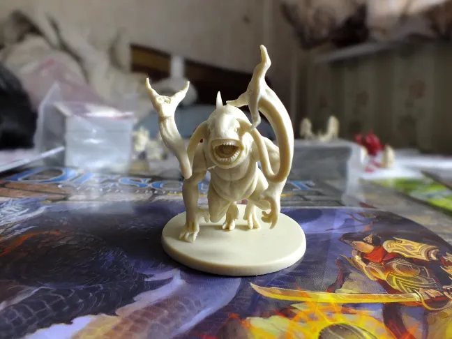 Cream-colored tentacled monster miniature close-up on the rulebook